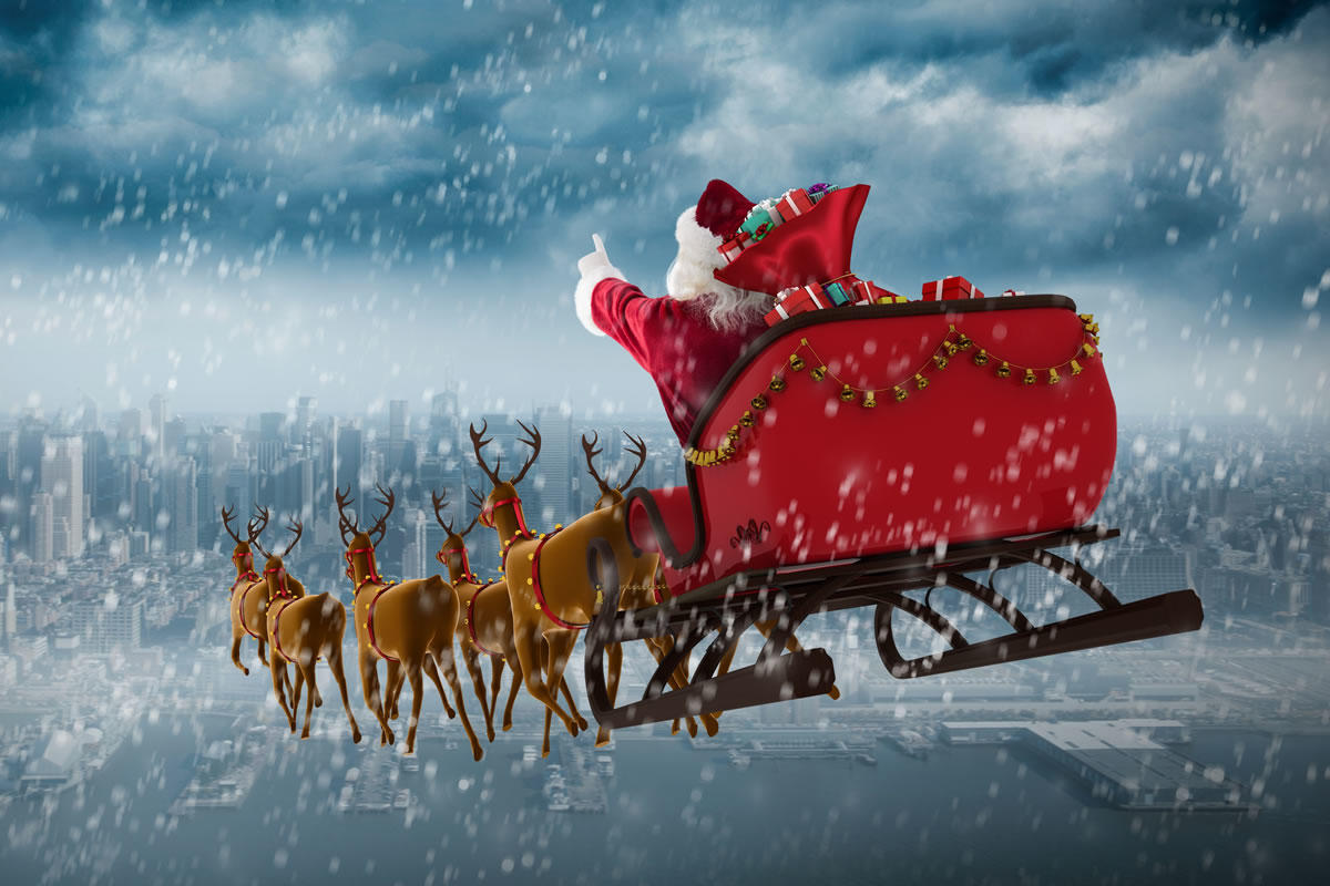 Santa flying in his sleigh with reindeers in snow
